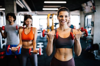 Mutlu insanlar sağlıklı kalmak için spor salonunda birlikte egzersiz yaparlar. İnsanlar spor eğitimi kavramları
