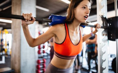 Güzel formda genç kadınlar spor salonunda çalışıyor.