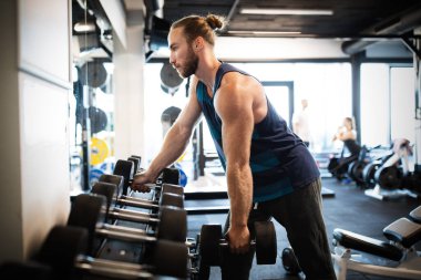 Genç formda sporcu spor salonunda çalışıyor.