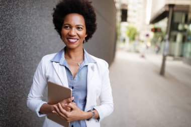 Şehirde dijital tabletli mutlu iş kadını