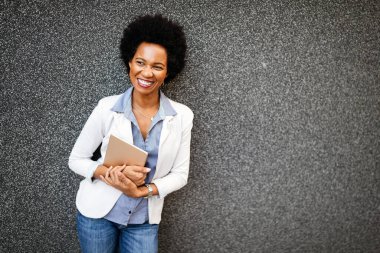 Şehirde dijital tabletli mutlu iş kadını