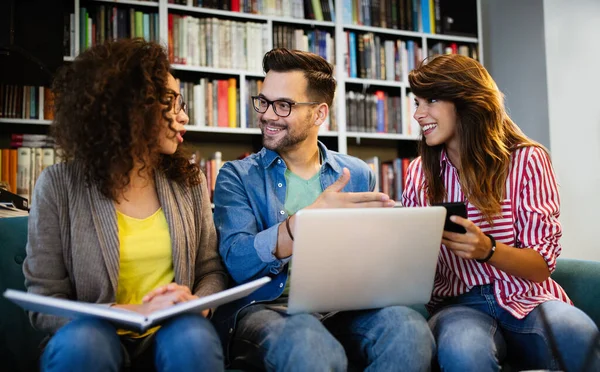 Happy young university students studying together. Group of multiracial people in college