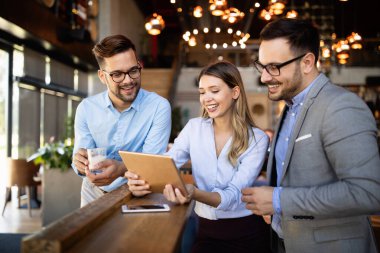 Genç iş adamları işyerinde eğleniyor ve sohbet ediyorlar.
