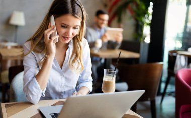 Kafede defter kullanan güzel esmer iş kadını.