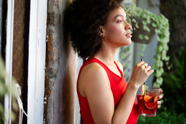 Beautiful black woman drinking healthy drink and smiling outdoor