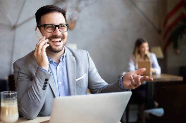 Kafede dizüstü bilgisayarın önünde oturan başarılı bir girişimcinin portresi..