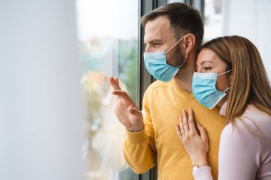 Koronavirüs karantinası sırasında evde izolasyon. Yüz maskesi takan kadın ve erkek. Coronavirus koruma ve önleme. Evde kal.
