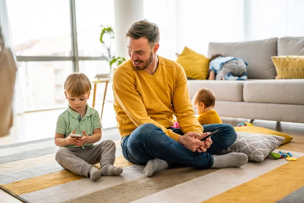 Mutlu baba ve oğul evde cep telefonuyla oyun oynuyor. Teknoloji bağımlılığı aile sorunu kavramı