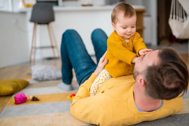 Mutlu genç baba evde küçük kızıyla oynuyor. Aile mutluluğu ev kavramını sever