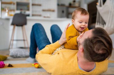 Sevecen baba ve küçük kızı evde oynaşıp kaynaşıyorlar.