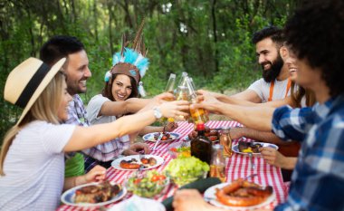 Bir grup arkadaş dışarıda barbekü partisi veriyor ve birlikte eğleniyorlar.