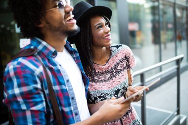 Yaz tatilleri, flört ve turizm konsepti - şehirde tablet ile gülümseyen çift