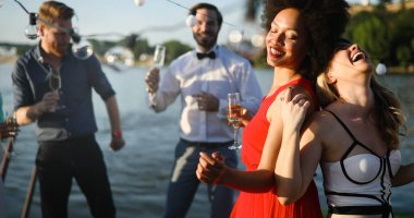 Bir grup mutlu arkadaş dışarıda toplanıp eğleniyorlar.