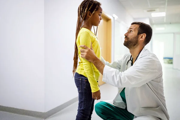 病院で悲しい女の子と会話をしている男性医師 小児科医 — ストック写真