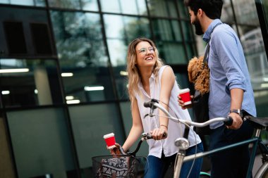 Küçük köpekleri olan, gülen genç bir çift şehirde konuşuyor.