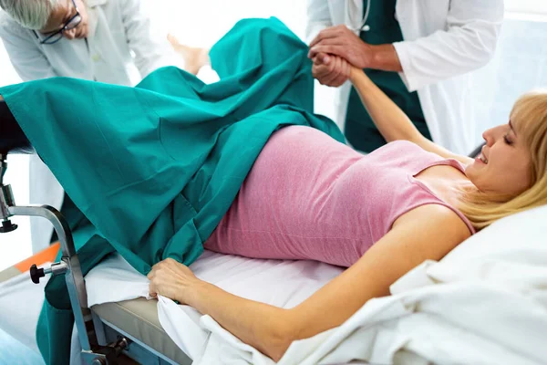 病院では若い美しい女性が出産するためにプッシュ 産科医が支援 — ストック写真