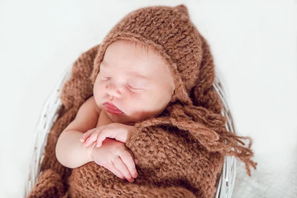 Νεογέννητο μωρό σε δεμένη καπάκι και μια κουβέρτα σε ένα καλάθι. — Φωτογραφία Αρχείου