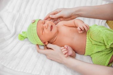 Yeşil pantolon içinde yeni doğmuş bir bebek.