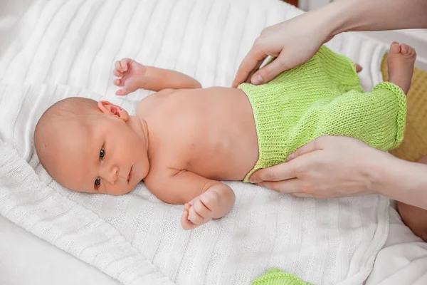 Een pasgeboren baby in de groene broek. — Stockfoto