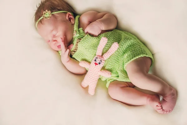 Pasgeboren babymeisje in een groene. — Stockfoto