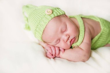 Yeni doğan bebek yeşil tulum ve şapka.