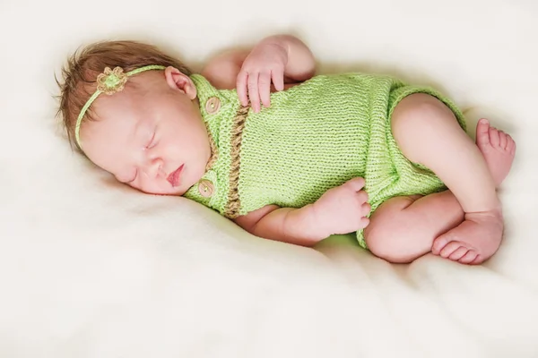 Pasgeboren babymeisje in een groene jumpsuit — Stockfoto