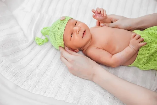 Um bebê recém-nascido nas calças verdes — Fotografia de Stock