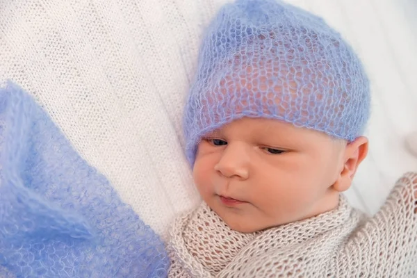 Een pasgeboren baby in een gebreide Blauwe gebreide cap. — Stockfoto