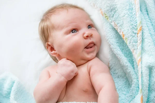 Νεογέννητο μωρό ξαπλωμένη καλύπτεται με μια πετσέτα, κοιτάζοντας γύρω. — Φωτογραφία Αρχείου
