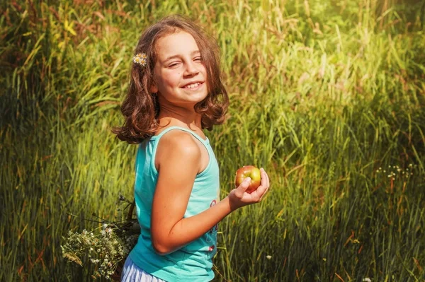 Child  girl with a basket of apples in the field. — Stock Photo, Image