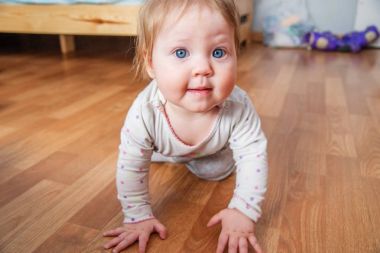 Bebek daire yerde sürünüyor. Tarama ve yürüyüş küçük bir çocuk öğrenir.