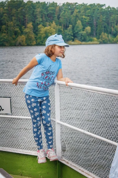 A child stands on the ferry across the river. — Stock Photo, Image