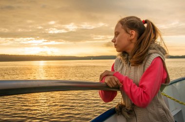 Çocuk akşam bulutlu havalarda nehrinde gemide olduğunu.