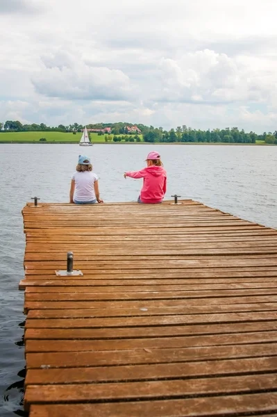 Çocuk ahşap bir iskele Nehri üzerinde oturmak