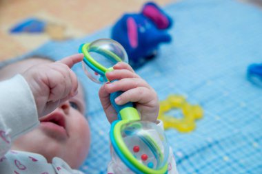 Şirin bir bebek beşiğinde oyuncaklarla yalan söylüyor.