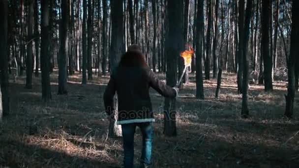 Il tipo attraversa la foresta con una torcia — Video Stock