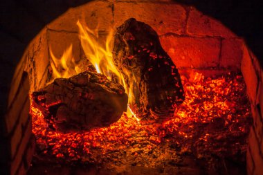 Bir şömine bulunan bir ateş yakar