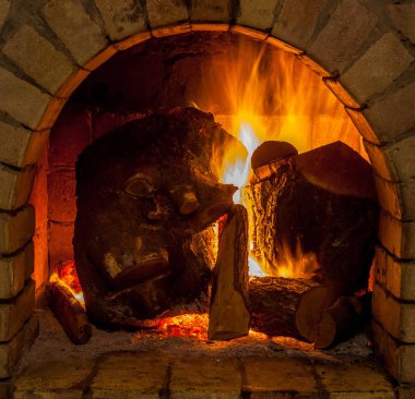 Bir şömine bulunan bir ateş yakar