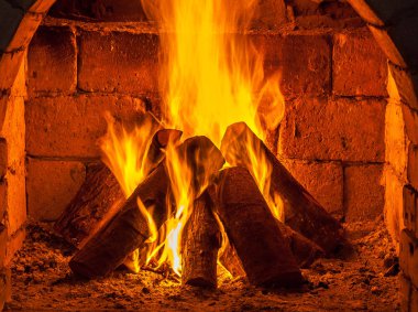 Bir şömine bulunan bir ateş yakar