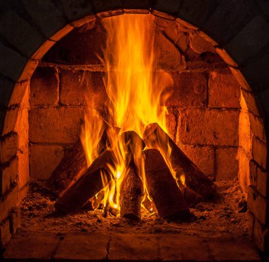 Bir şömine bulunan bir ateş yakar