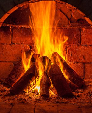 Bir şömine bulunan bir ateş yakar