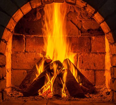 Bir şömine bulunan bir ateş yakar