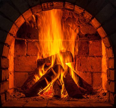 Bir şömine bulunan bir ateş yakar