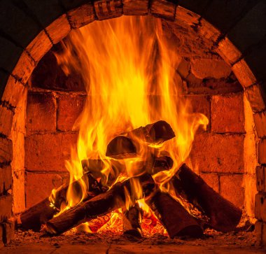 Bir şömine bulunan bir ateş yakar