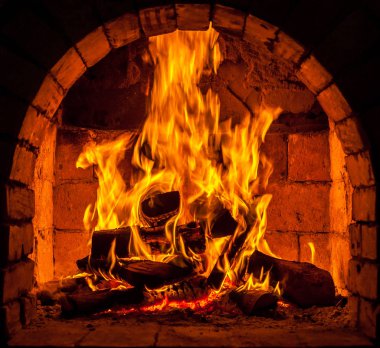 Bir şömine bulunan bir ateş yakar