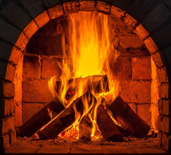 Um fogo queima em uma lareira — Fotografia de Stock