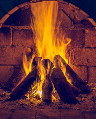 Bir şömine bulunan bir ateş yakar