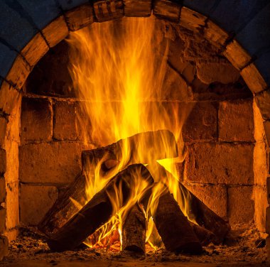 Bir şömine bulunan bir ateş yakar