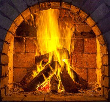 Bir şömine bulunan bir ateş yakar