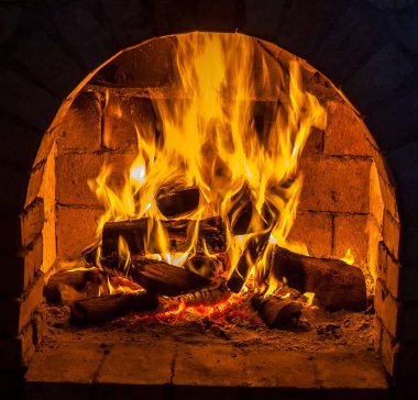 Bir şömine bulunan bir ateş yakar